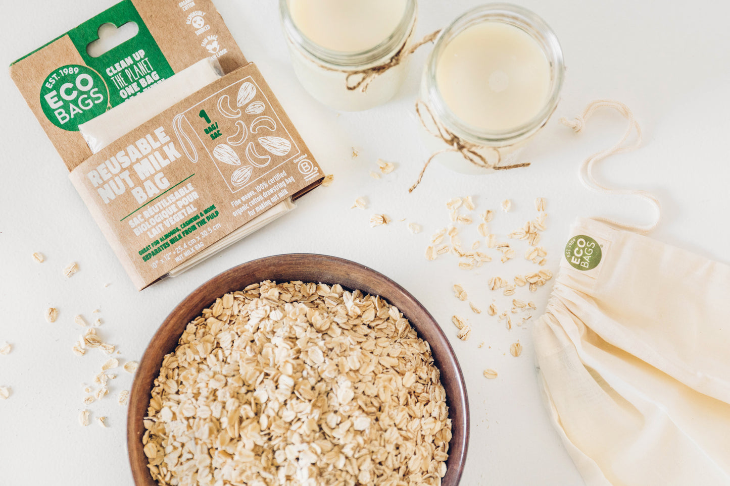 Oats in a bowl with eco-friendly packaging and bags on a white background