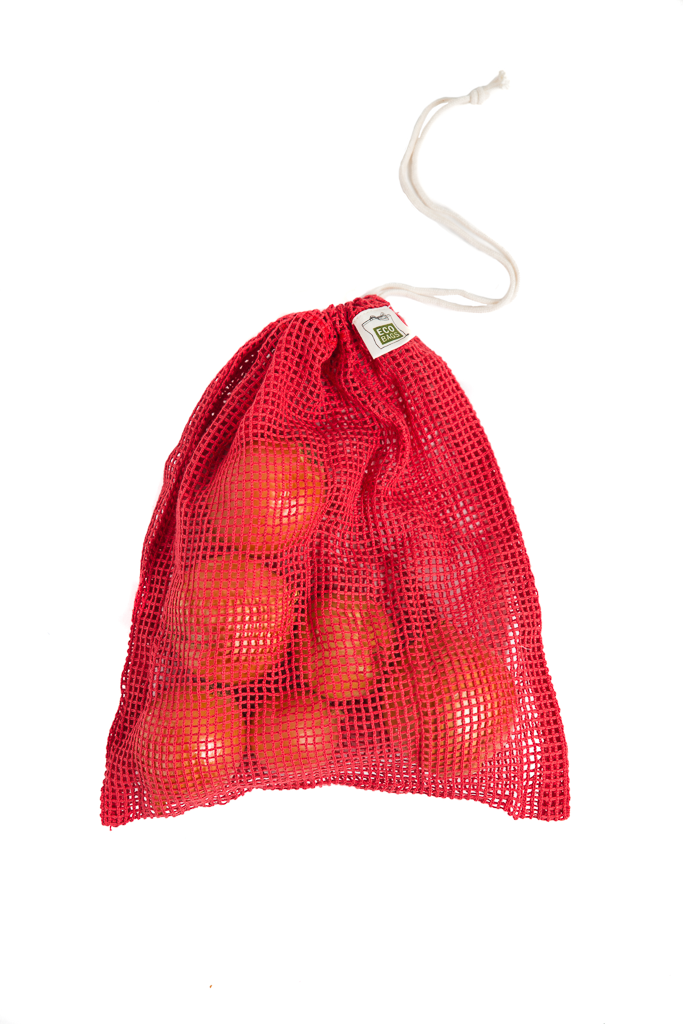 A red, chili colored cotton mesh produce bag contains small to medium sized onions, closed with a drawstring.